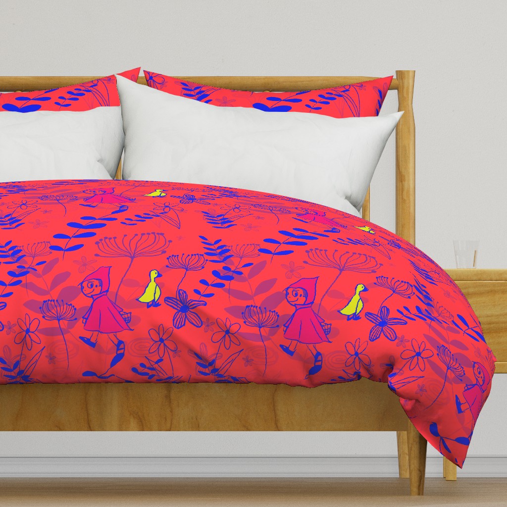 Bed with duvet cover with Red Riding Hood pattern on it.